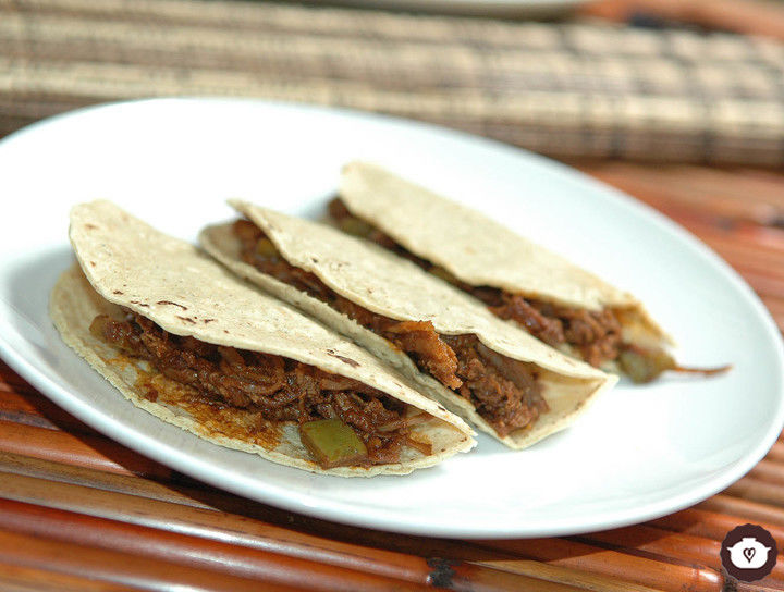 Tacos de carne deshebrada en salsa de pasilla
