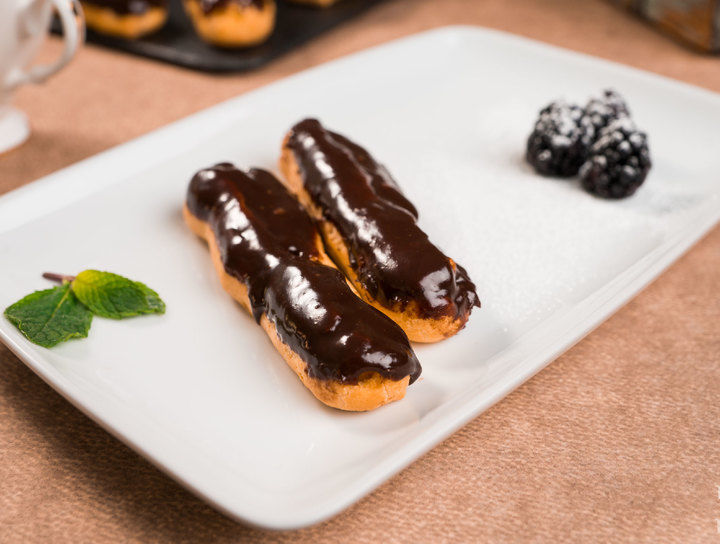 Eclairs rellenos de crema pastelera cubiertos con ganache de chocolate