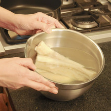 Poner a remojar el bacalao en suficiente agua con sal, al menos durante 1 día completo. Cambiar el agua varias veces.