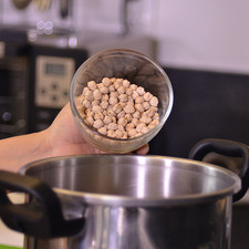 Colocar los garbanzos con agua y sal en una olla de presión. Tapar la olla y sellar bien en el número 2. Poner a fuego alto, cuando comience a silbar, bajar la lumbre al mínimo y cocer durante 25 minutos. Dejar enfriar por completo antes de abrir la olla. Escurrir y reservar.