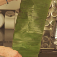 Pasar por el comal caliente la hoja de plátano para que no se rompa al doblar.