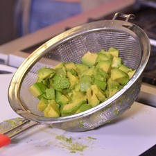 Picar la pulpa de los aguacates en cubos y colocar inmediatamente dentro de un colador o escurridor.