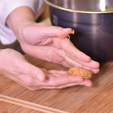 Tomar una cucharada de la mezcla y hacer una bolita. Aplastar ligeramente con la cuchara y darle forma de nugget. Repetir hasta tener toda la mezcla lista.