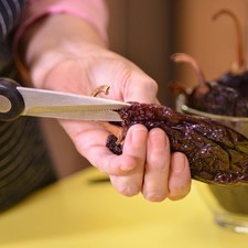 Hacer un corte por un lado de los chiles con el cuchillo para retirar las semillas, conservando el rabo.