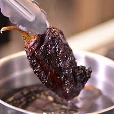 Colocar los chiles anchos en un tazón con agua bien caliente y dejar remojar hasta que se suavicen, escurrir y reservar.