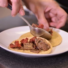 Calentar las tortillas en el comal y rellenar cada tortilla con un poco de la mezcla. Añadir trocitos de chicharrón y doblar para formar el taco.
