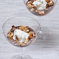 Dorar la almendras con una cucharadita de mantequilla. Colocar la mezcla en copas de vidrio y decorar con la crema y las almendras.