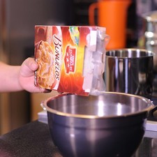 Colocar en un tazón la harina para buñuelos. Añadir con mucho cuidado el agua hirviendo.