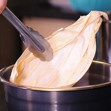 Colocar las hojas de maíz en un tazón con agua caliente para hidratarlas, durante 10 minutos.