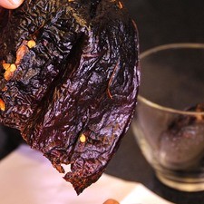 Desvenar los chile anchos. Hervir las pieles de los chiles en una olla con un poco de agua durante 5 minutos. Dejar reposar 5 minutos más hasta que se suavicen.