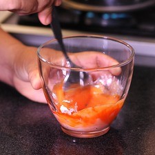 Para preparar el glaseado, mezclar el azúcar pulverizada y el jugo de naranja en un tazón, revolver bien con una cuchara, agregar dos gotas de colorante amarillo y tres de rojo, mezclar bien.