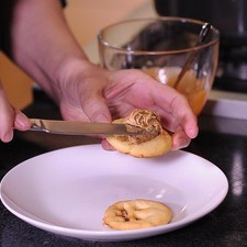 Colocar un poco de la mantequilla sobre la galleta sin cara, y colocar encima la otra galleta con cara, presionando para unirlas como si fuera un sándwich.