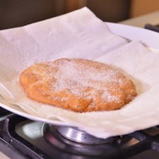 Sumergir en el aceite, voltear una vez hasta que tome un color dorado. Freír un buñuelo a la vez. Escurrirlo muy bien. Bañarlo con azúcar y reservar.