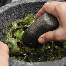 En el molcajete moler los chiles tostados, si no se tiene molcajete se pueden apachurrar los chiles en la olla con el machacador.