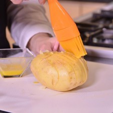 Agregar un poco de mantequilla derretida con la ayuda de una brocha sobre la parte superior de cada papa. Añadir un poco de aceite de oliva y espolvorear un poco de sal y pimienta.