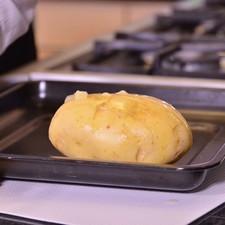 Colocar las papas en una charola y hornear durante 40 minutos a 350°F (175°C) o hasta que queden crujientes por encima y suaves por dentro.
