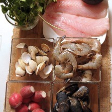 Ingredientes para toda la receta: 1/4 cucharita de comino molido 1/4 pieza de cebolla blanca 3 ramas de epazote 8 piezas de tomate verde (tomatillo) 1/4 cucharita de pimienta negra molida 1 diente de ajo 2 piezas de chile serrano 1 kilogramo de maíz pozolero precocido 1/2 manojo de perejil 1/2 manojo de cilantro 1 kilogramo de pescado blanco 500 gramos de camarón 40/50 300 gramos de mejillones 300 gramos de almeja blanca sal al gusto