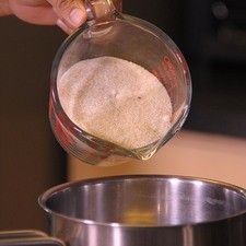 En otra olla combinar azúcar, miel y 1 1/2 taza de agua cocer por 3 minutos a fuego alto hasta que el azúcar se disuelva, agregar las cáscaras y cocinar por 25 minutos hasta que la mayoría de la miel se haya absorbido, meneando constantemente, sacar del fuego.