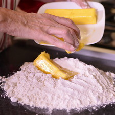 Para la masa: Precalentar el horno a 350 F (180 C). Cernir la harina antes de medirla y hacer con ella un volcán, colocar en el centro la mantequilla, el huevo, el agua fría y la pizca de sal.