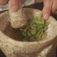 Con un mortero, moler las hojas de albahaca con el aceite de oliva. Colocar en un tazón, agregar el jugo de limón y el ajo picado finamente.