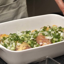 Picar las cebollitas con todo y rabo, esparciendo sobre las piezas de pollo.