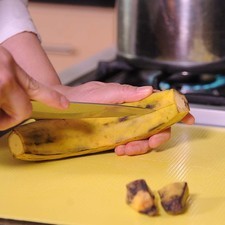 Hacer un corte en la cáscara a lo largo de todo el plátano y cortarlo en 4 partes para facilitar pelarlo después.