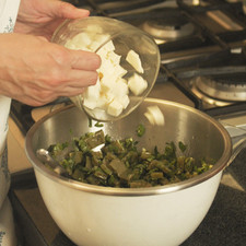 Colocar los nopales en un tazón, mezclar con orégano, pimienta y aceite de oliva, agregar cilantro y chile picados, sazonar con sal al gusto y mezclar bien. Agregar queso en cubos.