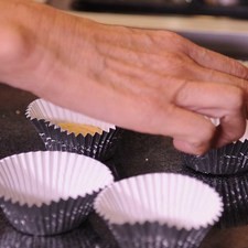 Acomodar las galletas en el fondo de cada molde de papel aluminio.