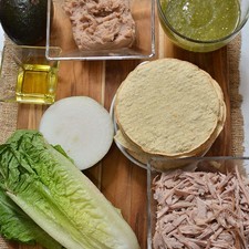 Ingredientes para toda la receta 1 taza de salsa verde picante desinfectante de verduras al gusto 10 piezas de tostadas de maíz 1/2 pieza de cebolla blanca 1 pieza de aguacate 1 pieza de lechuga orejona 1 taza de frijoles refritos 2 tazas de pierna deshebrada Nuevo