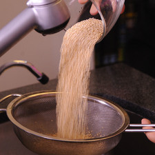 Colocarla la quinoa en un colador y enjuagar bajo el chorro de agua moviendo con una cuchara. Escurrir.