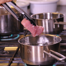 Cocer la carne de puerco, en una olla honda con suficiente agua y sal.