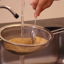 Lavar la quinoa bajo el chorro de agua, mover con la mano o una cuchara para que se limpie bien y escurrir.