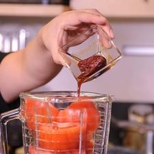 Agregar los chiles chipotles adobados, el diente de ajo, cebolla y moler.