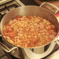 Verter las alubias cocidas con el caldo en la olla del sofrito y condimentar con sal, pimienta y comino.