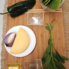 Ingredientes para toda la receta 300 gramos de queso manchego 1/4 cucharita de orégano seco 3 ramas de epazote 2 cucharadas de aceite de oliva 1 pizca de bicarbonato de sodio 1 pieza de chile poblano 1/4 pieza de cebolla morada 10 piezas de penca de nopal
