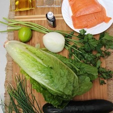 Ingredientes para toda la receta. 10 ramas de perejil desinfectante de verduras al gusto 300 gramos de salmón ahumado 1/4 cucharita de pimienta negra molida 1 pieza de lechuga orejona 1/4 pieza de cebolla blanca 1/2 manojo de cebollín 1 pieza de pepino europeo Nuevo 3 cucharadas de aceite de oliva 1 pieza de limón
