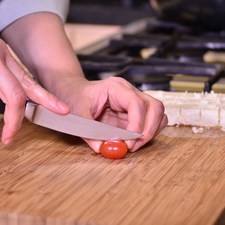 Cortar los tomatitos cherry tipo uva a la mitad a lo largo pero de forma transversal, es decir, un poco en diagonal.