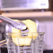 Colocar 2 rebanadas de piña en la licuadora y molerlas bien. Picar el resto de la piña en trozos pequeños.