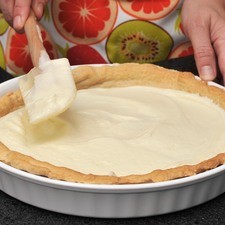 Colocar el queso batido y endulzado en la base del pay.