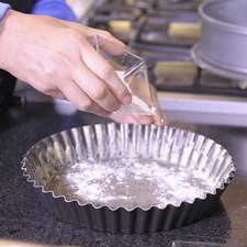 Engrasar con las dos cucharadas de mantequilla y enharinar el molde para tarta.