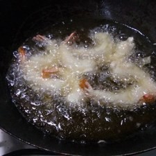 Calienta aceite, toma los camarones de la colita y sumérgelos en la mezcla. Fríe.