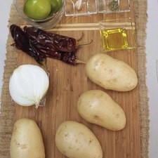 Ingredientes para receta 4 piezas de papa blanca 2 cucharadas de aceite de oliva 1/2 pieza de cebolla blanca 4 piezas de chile guajillo 1 diente de ajo 4 piezas de tomate verde (tomatillo) 1/4 cucharita de orégano en polvo sal al gusto