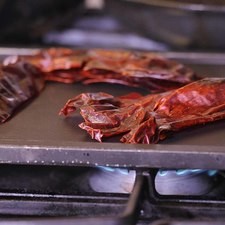Poner a calentarr las pieles de los chiles sobre el comal dando vuelta para que no se quemen. Solo hasta que despierte su aroma.