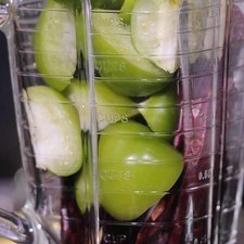 Agregar los tomates verdes cortados en cuartos, orégano, un poco del agua y moler hasta obtener una mezcla homogénea.