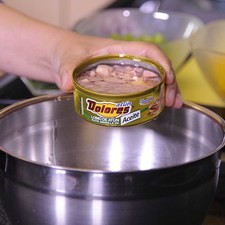 Mezclar en un refractario el atún en aceite desmenuzando con un tenedor.