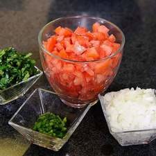 Picar finamente el chile, cebolla, las ramas de cilantro y picar el jitomate en cubos pequeños.