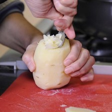 Cortar la parte superior de la papa y con la ayuda de un cuchillo ahuecar la papa para que quede en forma de cilindro.