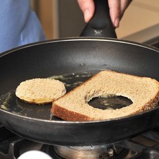 Derretir una cucharada de mantequilla en una sartén. Dorar el marco de pan y el círculo de pan en la mantequilla durante 2 minutos por un lado y voltear ambos por el otro.