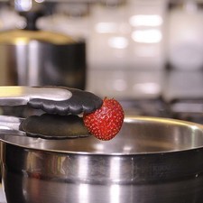 Se desinfectan las fresas en un tazón con agua y gotas desinfectantes.