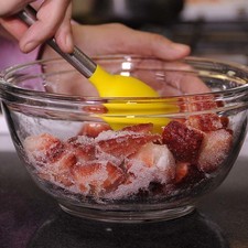 Poner las fresas en un tazón y agregar el azúcar, mezclar en forma envolvelte hasta que se forme un jarabe translúcido.